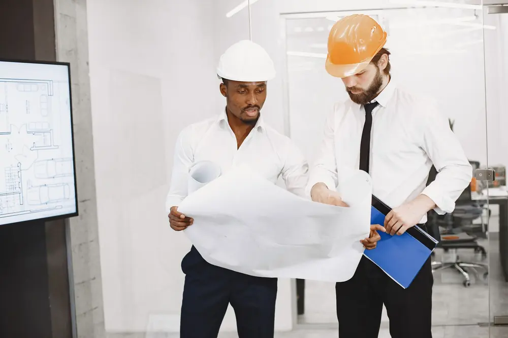 Bureau d'études — techniciens examinant les plans d'un projet de chantier